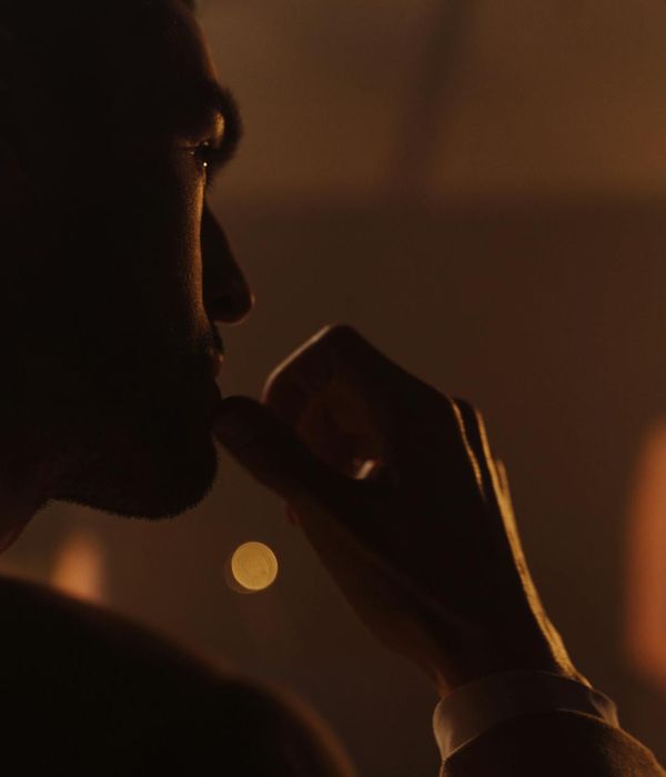 Person stretching gently indoors with soft, ambient lighting.